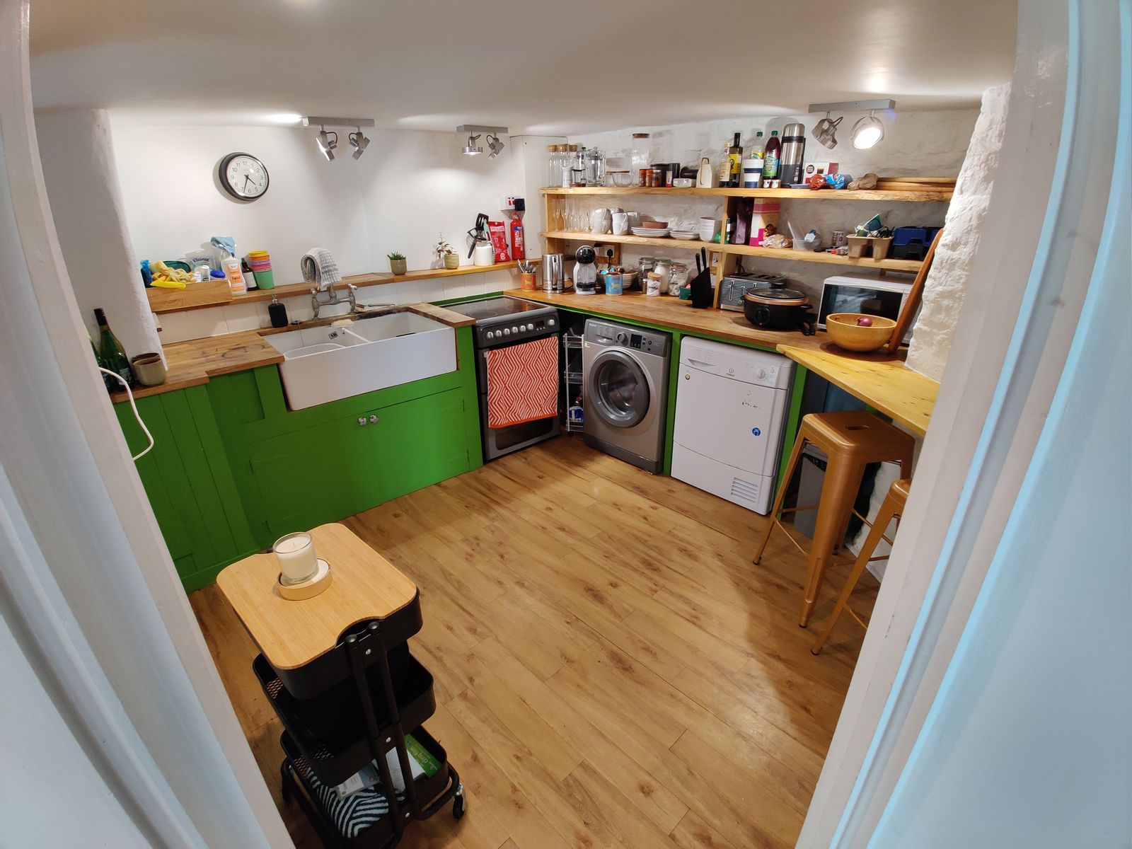 The kitchen with green cabinets and wood worktops
